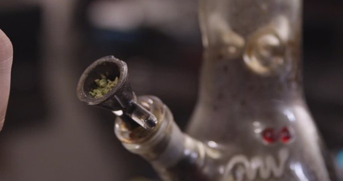 Close Up - Cannabis is packed into a dirty bong bowl - shot on RED