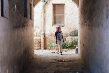 a young girl walked round the corner in Stonetowns narrow streets with a bag over her head