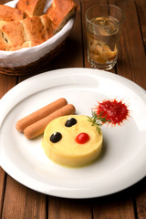 mashed potatoes with olive eyes and sausages