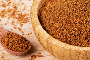 Bowl full of dark brown sugar on a wooden background