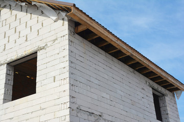 House under construction with unfinished roof fascia boards and with no soffit panels