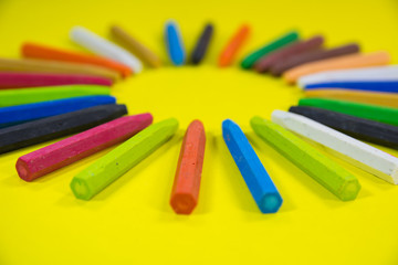 low angle closeup view of crayons colors on vibrant yellow background crayons in circle shape
