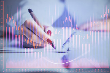 Double exposure of woman's hands making notes with forex graph hologram. Concept stock market analysis.