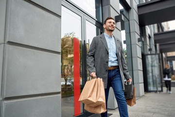 Adult man with shopping bags walking outdoor