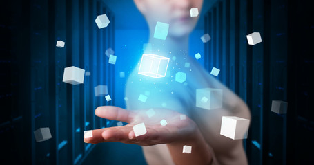 Person holding hologram projection displaying white cubes in server room