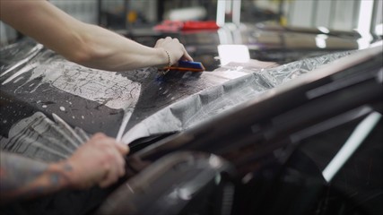 closeup peeling off protective film from a car