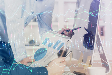 Double exposure of chart with businessman typing on computer in office on background. Concept of...