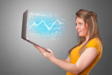 Woman holding laptop projecting financial information, diagrams and charts