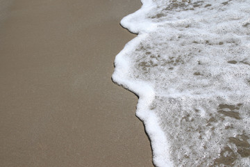 Abstract soft waves on the brown sand beach and white bubbles background