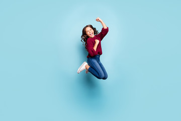 Full length body size photo of cheerful positive preteen screaming shouting wearing denim burgundy sweater jumping rejoicing overjoyed isolated blue vivid color background