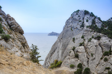 Fototapeta na wymiar Mountain landscape by the sea. Travel to the sea, rock steep slope and mountain vegetation.