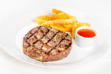 Grilled cutlet on a white plate shot isolated on a white background