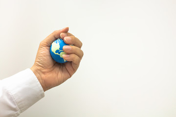 Fototapeta na wymiar Global business concept, Closeup of businessman hand holding mini world ball in his fist on white background and copy space for text.