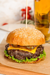 Cheeseburger pierced by a wooden skewer shot on a wooden board