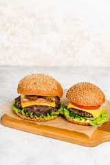 Cheeseburger pierced by a wooden skewer shot on a wooden board