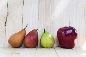 single red apple and pear on wooden background