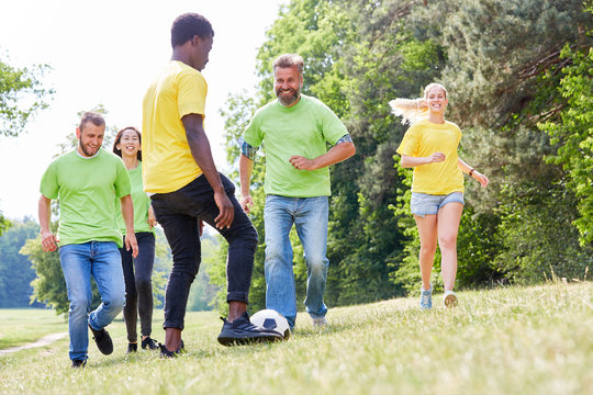 Gruppe junger Leute spielt zusammen Fußball