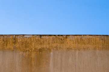moisture on cement wall outside building, blue sky background