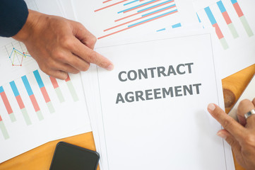 Business discussions and contract agreements. Business people point to contract agreement.