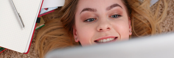 young beautiful woman lie on floor have a lot of work hold tablet in arms