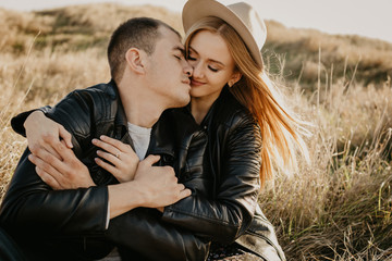 Happy young couple enjoying outdoors during sunset .