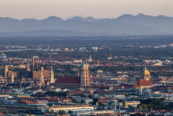 Abendliches Panorama von München mit der Frauenkirche vor den Alpen