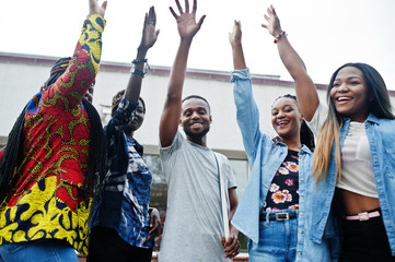 Group of five african college students spending time together on campus at university yard. Black afro friends studying. Education theme.