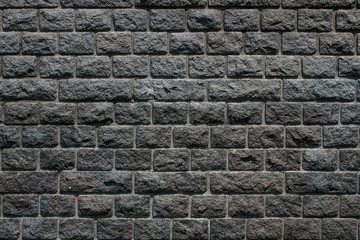 Dark gray big brick wall background texture with various colors details