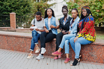 Obraz na płótnie Canvas Group of five african college students spending time together on campus at university yard. Black afro friends studying. Education theme.