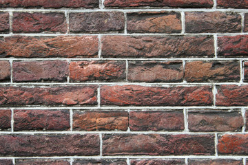 Detailed close up of a dark modern clean red and orange brickwork wall background texture