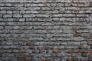 Dirty old weathered grey painted reddish brickwork wall background texture