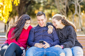 Fototapeta premium Three friends laughing looking a mobile phone