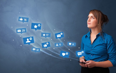 Young person using phone with flying social media icons around