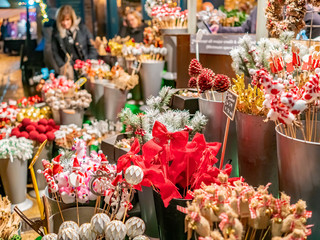 Selective focus on red bow Christmas decorations among various other festive decorations for sale at the 2019 Christmas market in York