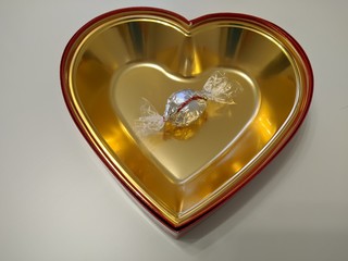 Silver candy on gold heart on white background