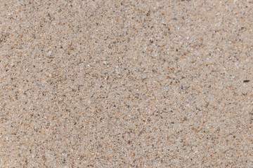 The sand background at the beach near the sea is beautifully arranged in sand