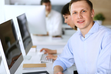 Cheerful smiling businessman headshot at work in modern office. Unknown casual dressed entrepreneur...