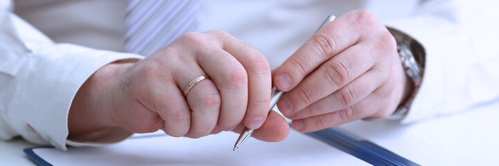 Male arm in suit and tie hold silver pen