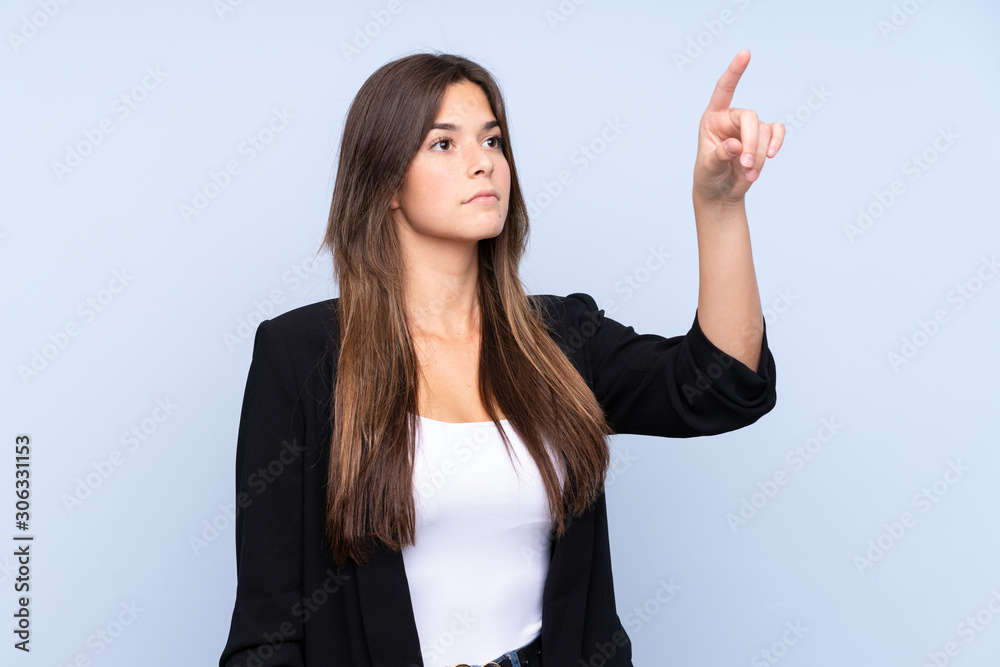 Wall mural young brazilian business woman over isolated blue background touching on transparent screen