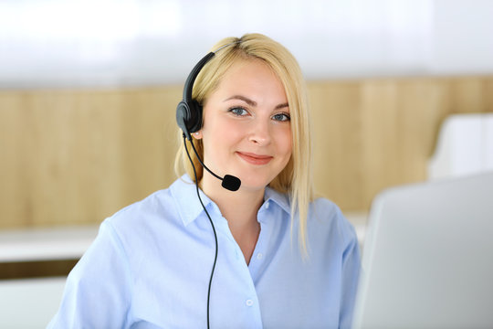 Call center. Blonde business woman sitting in headset at customer service office. Concept of telesales business or home office occupation