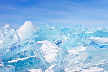 Obraz premium Ice hummocks on Baikal Lake in a sunny frosty day. Unusual winter landscape with beautiful transparent ice floes on a background of blue sky. Natural cold background
