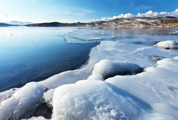 Freezing Baikal Lake in December. Thin ice in Hul Bay and the icy shore of Olkhon Island. Beautiful winter landscape, natural background