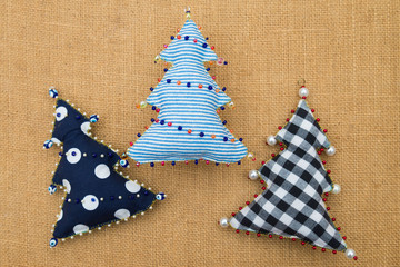 3 Handmade  textile cotton fabric naive retro style Christmas trees ornament decorated with beads on burlap background