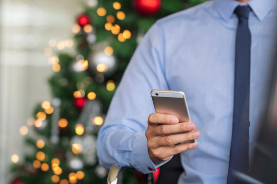 Businessman using phone in christmas time