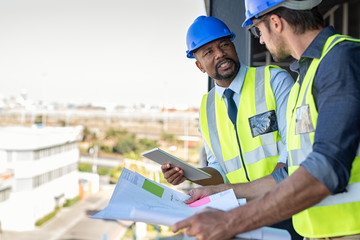 Construction workers discussing blueprint