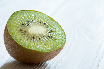 Half of Fresh  kiwi fruit on a wooden white table. Front view.