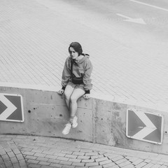 Black and white shot of Young adult female posing for photo on parking