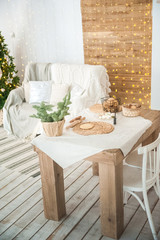 Details of the decorated New Year's interior. Scandinavian living room and kitchen for Christmas. The comfort of homely rustic decor.