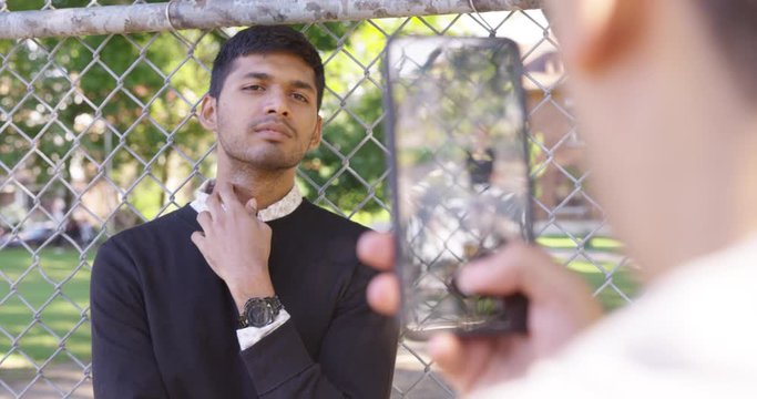 Indian man poses smart and elegant as his friend takes a picture of him in the park - Slow Motion - shot on RED