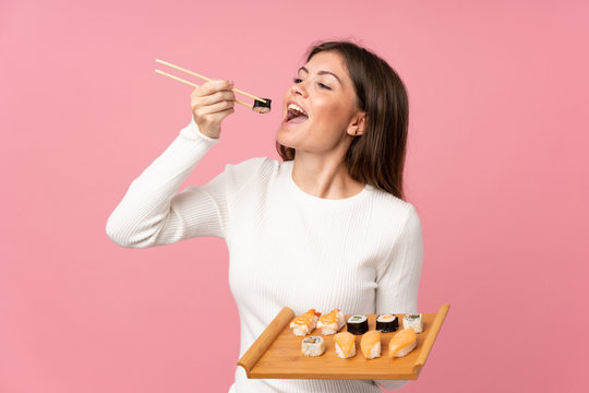 Young Girl With Sushi Over Isolated Pink Background